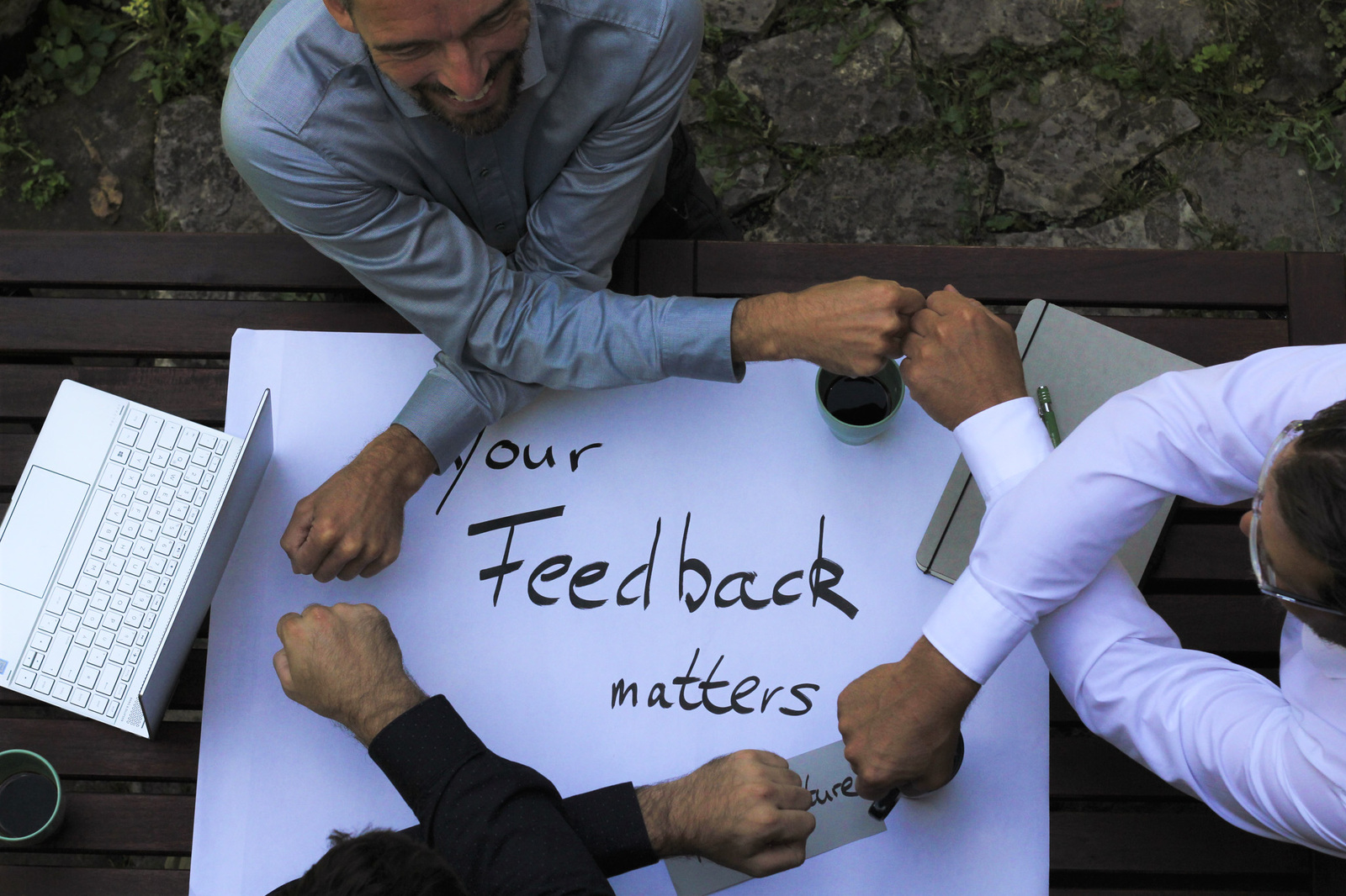 "Feedback Matters - drei Personen geben sich die Faust"
