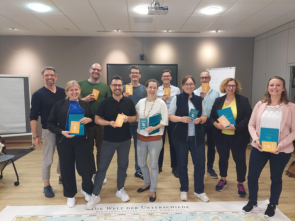 "Frisch zertifizierte MapsTell Guides zeigen Ihre Zertifikate auf der Bodenkarte
                stehend"