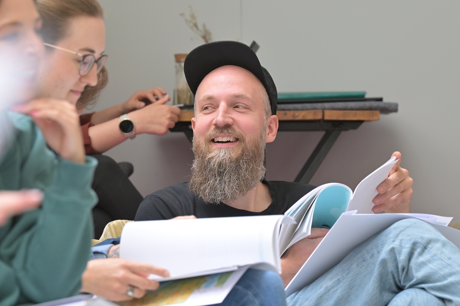 "Freundlich interessiert schauender Teilnehmer im Workshop nach eigenem
                Aha-Moment"