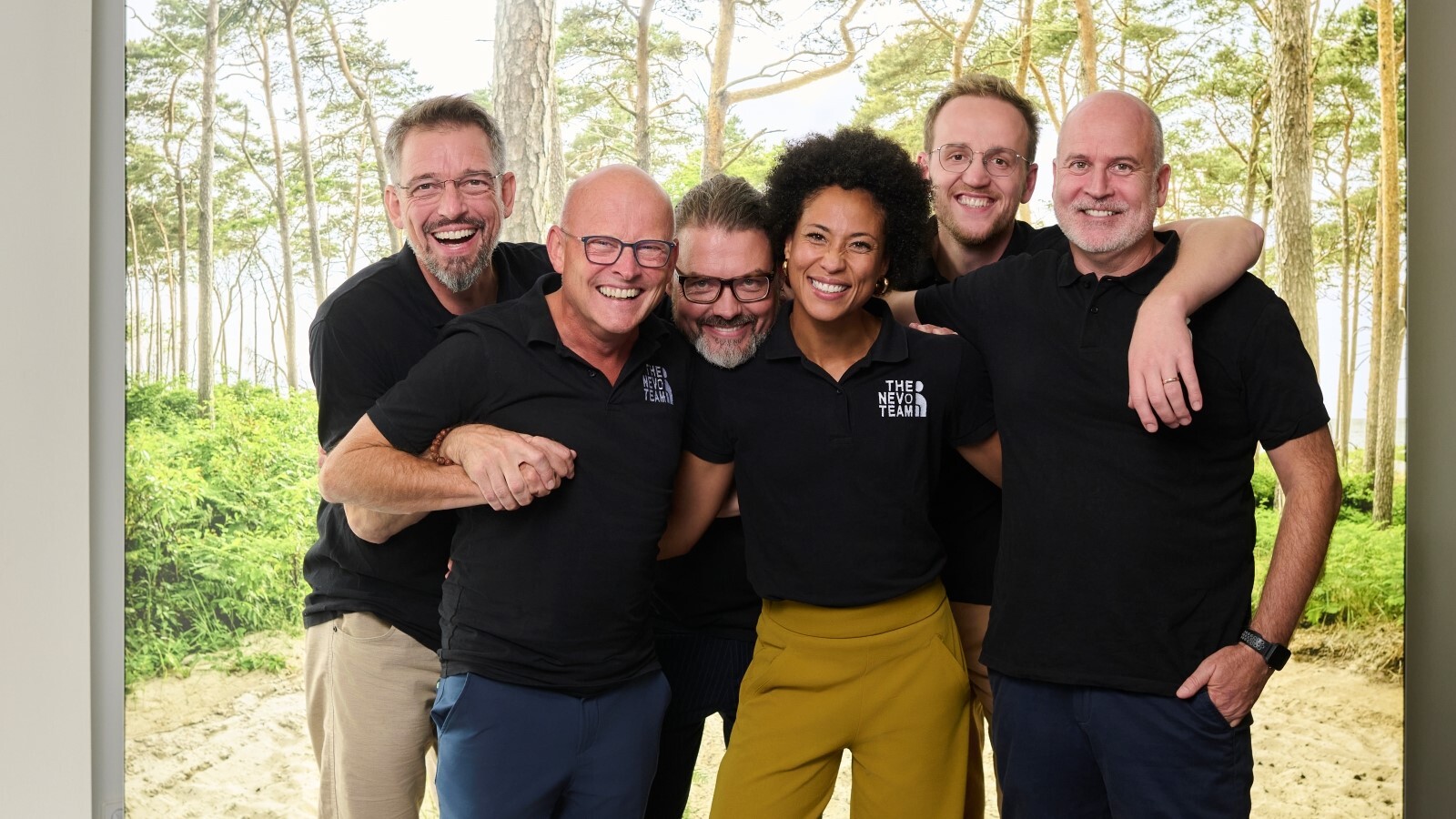 "Das nevo Team steht in freudiger Umarmung eng beieinander."