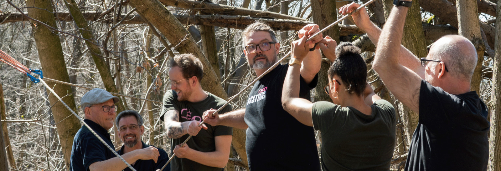 "Nevo Team baut eine Seilrutsche auf und zieht gemeinsam an einem Kletterseil"